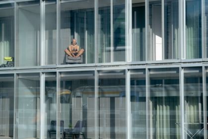 Homem toma sol da janela do apartamento, vitamina D
