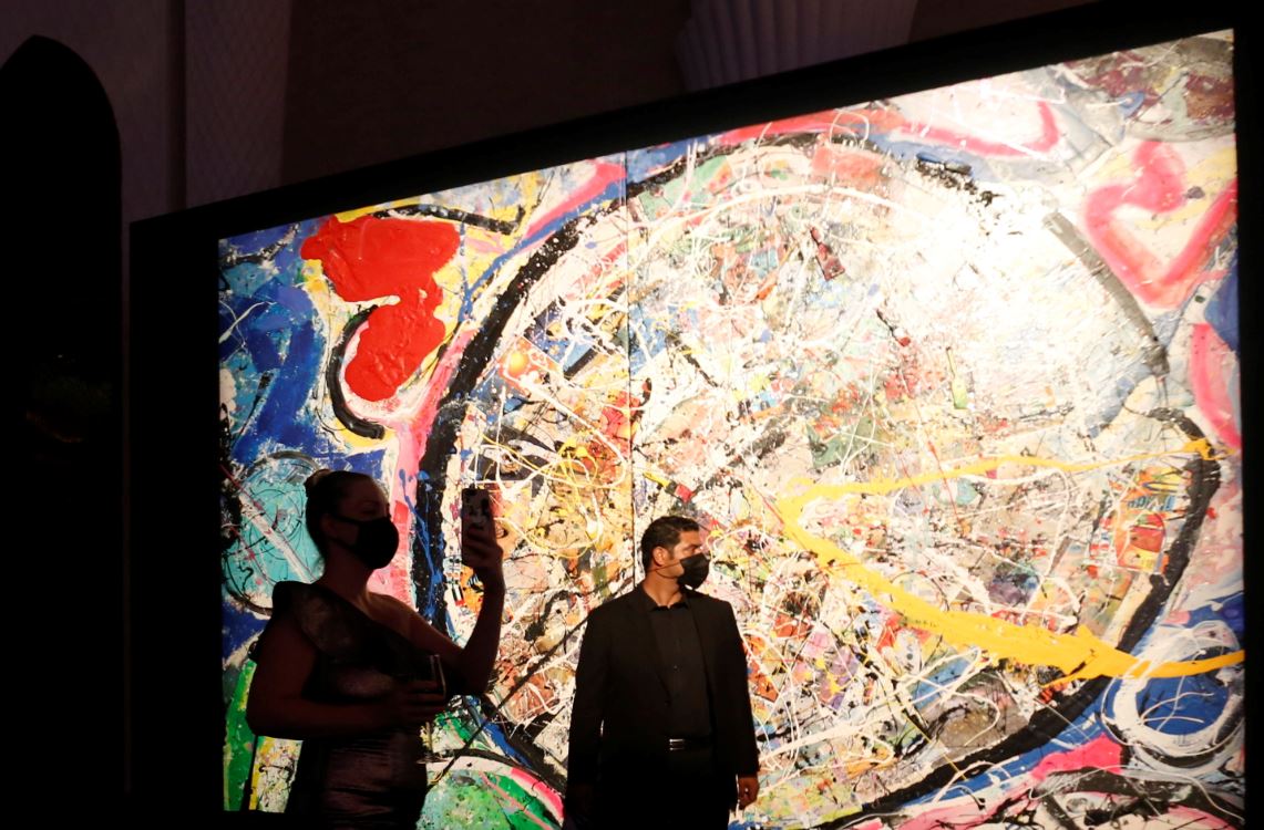 Visitante tira foto ao passar por obra do artista Sacha Jafri em Dubai