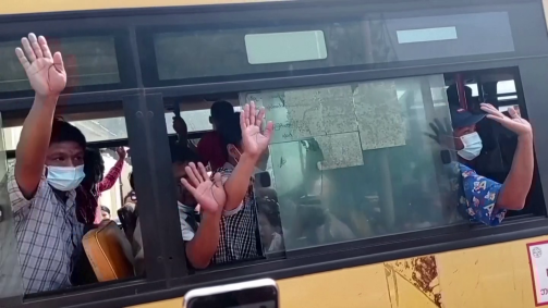 Dentro de ônibus, pessoas acenam ao deixar prisão em Mianmar