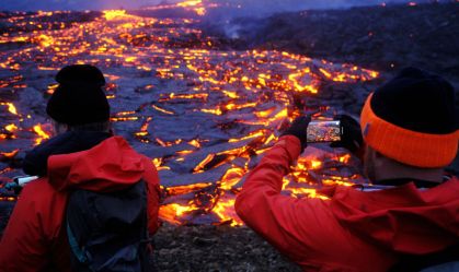 Turistas tiram foto perto da crosta de magma de vulcão na Islândia