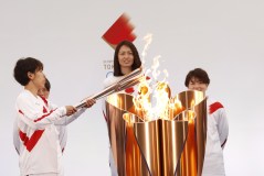 Azusa Iwashimizu (E) acende a tocha no caldeirão de celebração em Fukushima