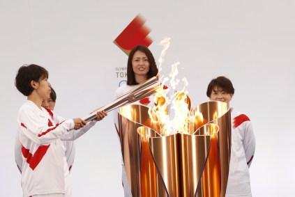 Azusa Iwashimizu (E) acende a tocha no caldeirão de celebração em Fukushima