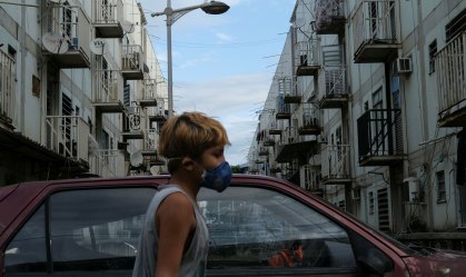Menino usa máscara de proteção na favela de Manguinhos, no Rio de Janeiro