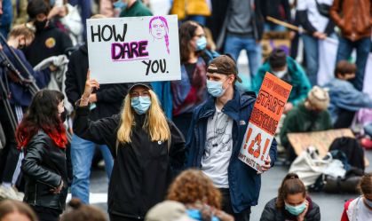 Manifestante carrega cartaz com imagem de Greta Thunberg