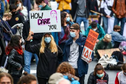 Manifestante carrega cartaz com imagem de Greta Thunberg