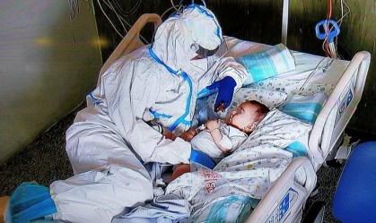 Enfermeira conforta bebê com Covid-19 que não podia receber visitas