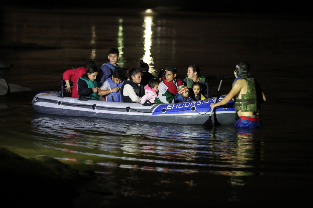 Imigrantes cruzando de barco o Rio Grande