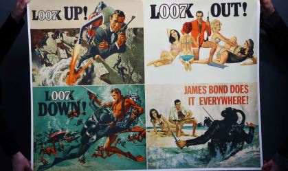 Funcionário segura pôster de filme de 007 que irá a leilão