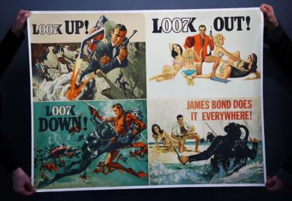 Funcionário segura pôster de filme de 007 que irá a leilão