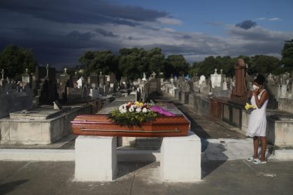 Mulher acompanha enterro da mãe, que morreu de Covid-19, em cemitério do Rio