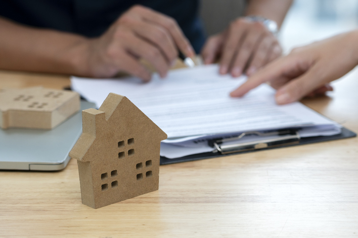 Pessoas revisam contrato para compra de imóvel