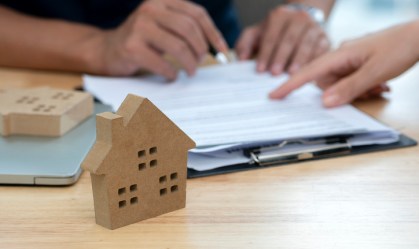 Pessoas revisam contrato para compra de imóvel