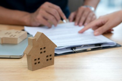 Pessoas revisam contrato para compra de imóvel