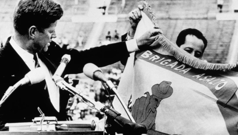 Presidente Kennedy dos EUA segura bandeira da Brigada 2506 e afirma que "eles retornarão a uma Havana livre" / Foto: Corbis Historical/Getty Images