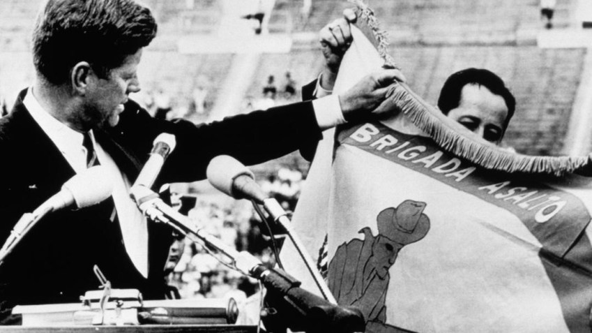 Presidente Kennedy dos EUA segura bandeira da Brigada 2506 e afirma que "eles retornarão a uma Havana livre" / Foto: Corbis Historical/Getty Images