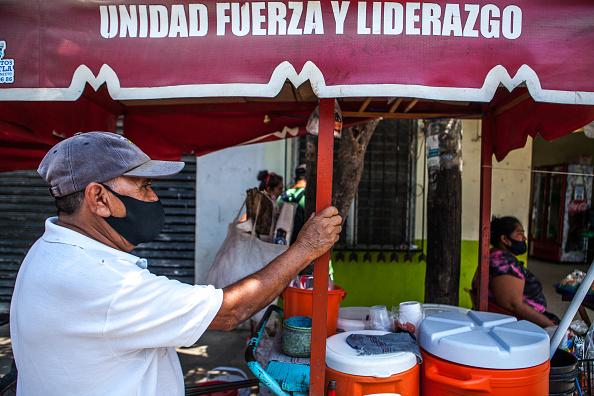 Vendedor de comida usando máscara facial na rua de Pochutla, México. Páis é a se