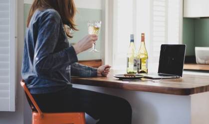 Mulher tomando vinho em casa