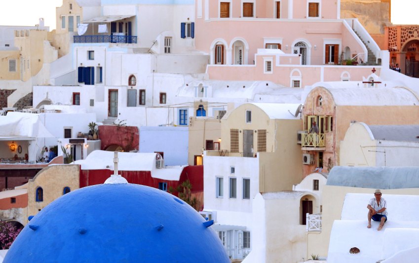 Homem assiste pôr-do-sol na ilha de Santorini, Grécia / Foto: Cathal McNaughton/Reuters (2.jul.2015)