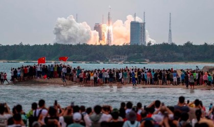 : Espectadores observam o foguete Longa Marcha-5B decolando na terça-feria (27) 