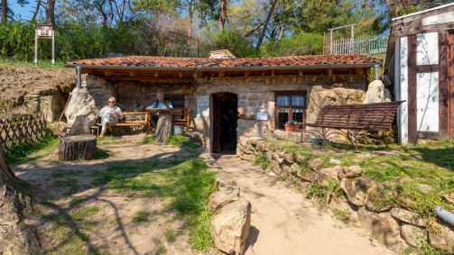 Turistas sentam-se em frente a uma caverna em Schäferberg. As moradias, esculpid