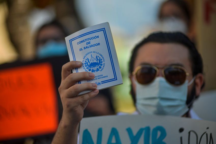 Manifestante segura a Constituição de El Salvador em protesto contra o governo Bukele / Foto: Camilo Freedman/APHOTOGRAFIA/Getty Images