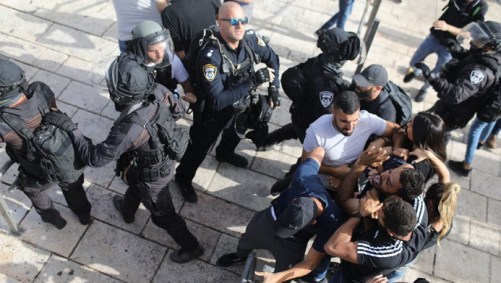 Membros disfarçados da segurança israelense prendem um manifestante palestino
