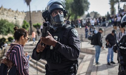 Um policial israelense aponta sua arma para o portão de Damasco