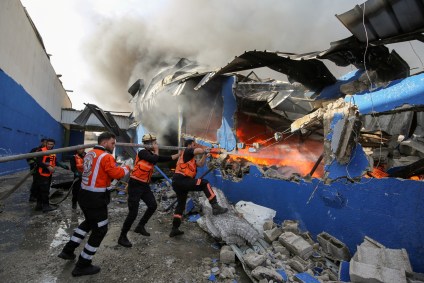 Bombeiros palestinos apagam chamas de fábrica atingida por míssil de Israel
