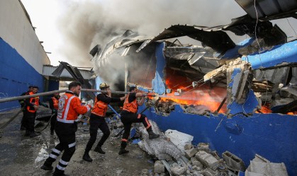 Bombeiros palestinos apagam chamas de fábrica atingida por míssil de Israel