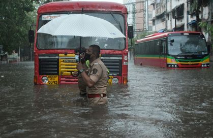 Policiais em ruas alagadas de Mumbai