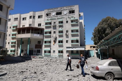 Médicos palestinos caminham na sede do Ministério da Saúde destruída após ataque