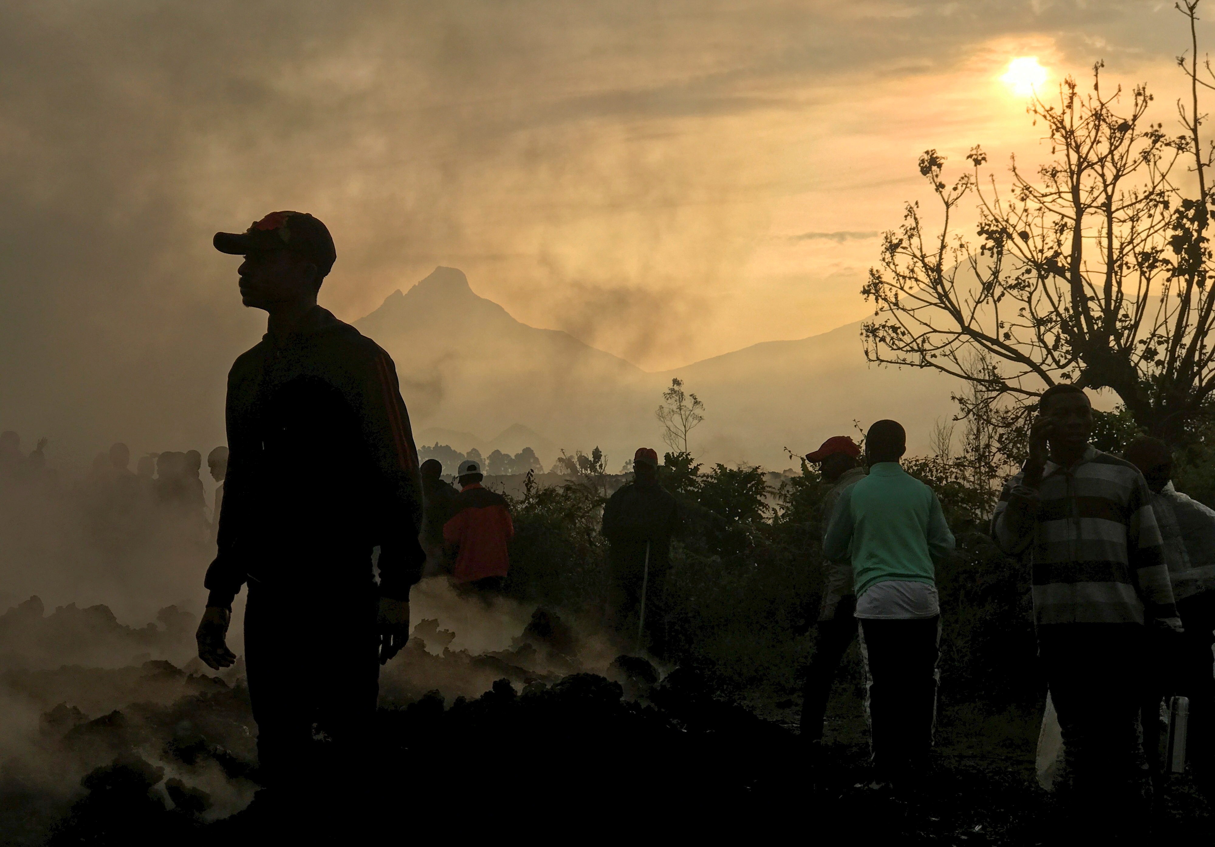 Moradores caminham perto de casas destruídas por lava de vulcão na RD Congo