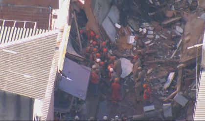 Bombeiros tentam tirar vítimas sob escombros de prédio