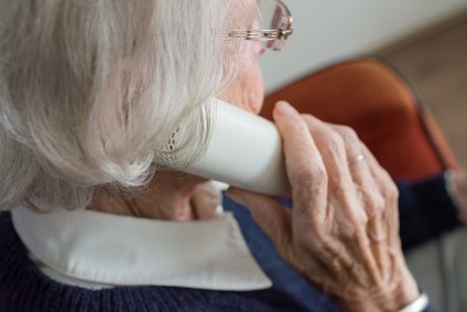 Mulher de cabelos brancos fala ao telefone