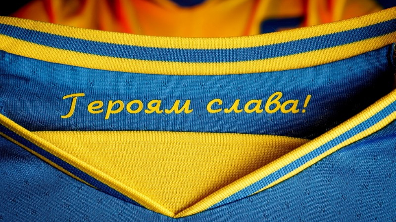 Camisa azul e amarela com slogan "Glória aos heróis"