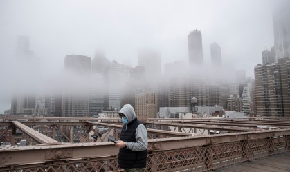 Homem de máscara caminha na ponte do Brooklin, em Nova York (EUA)