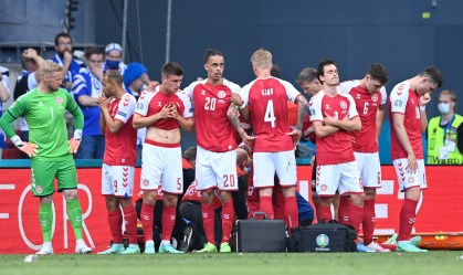 Jogadores parecem abatidos enquanto Christian Eriksen recebe assistência médica