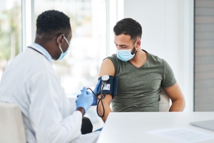 Médico aferindo pressão do paciente
