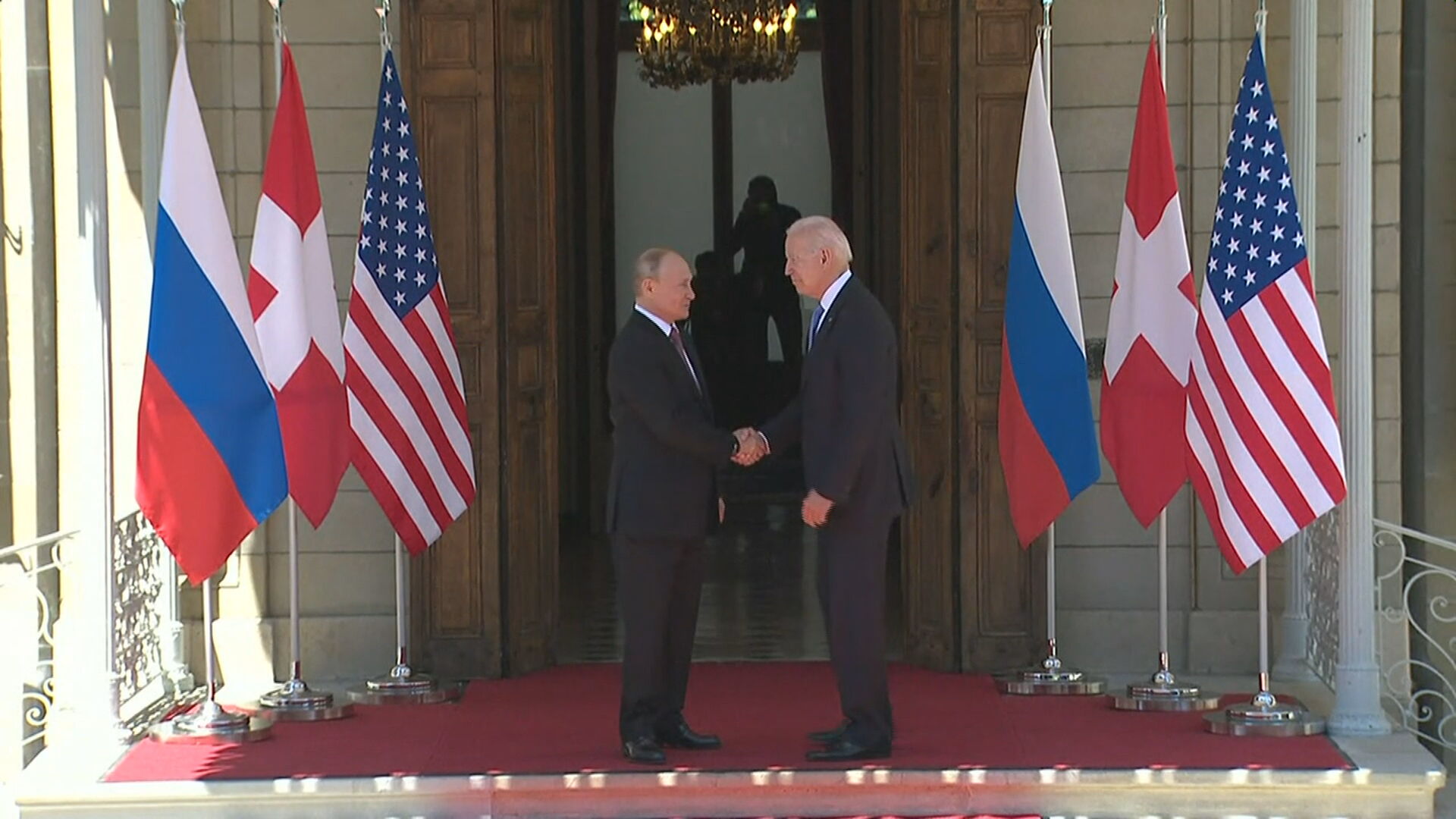 Vladimir Putin e Joe Biden se cumprimentam durante encontro em Genebra