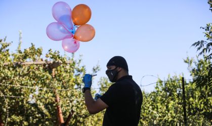 Homem palestino segura balão preso a explosivo 