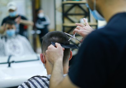 Cabeleireiro e cliente usam máscaras durante atendimento na Alemanha