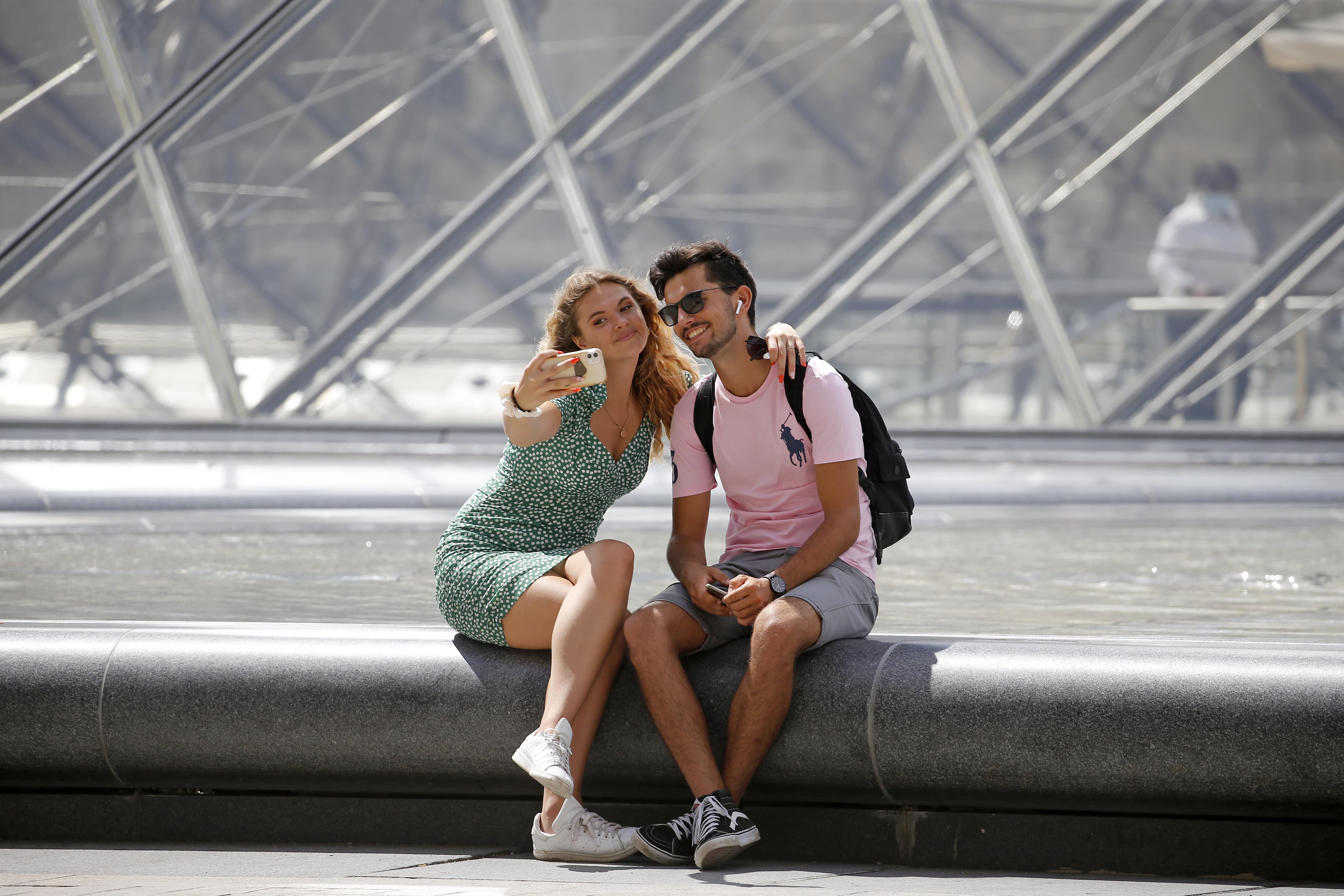Turistas tiram foto em frente à pirâmide do Louvre Turistas tiram foto em frente à pirâmide do Louvre