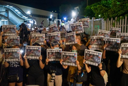 Apoiadores posam com última edição do Apple Daily em Hong Kong