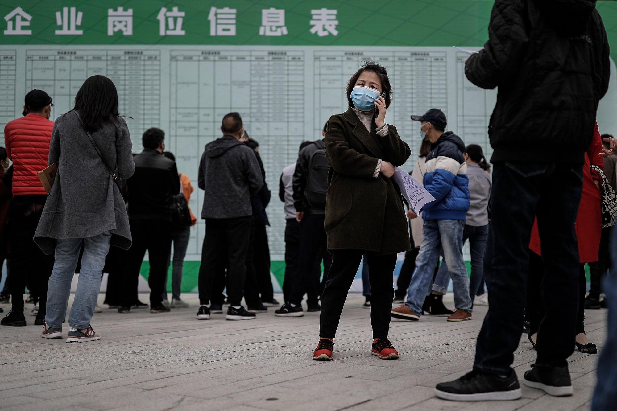 Crise da Covid-19: candidata faz ligação em uma feira de empregos em Wuhan