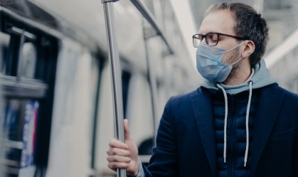 Homem usa máscara e óculos de grau no metrô durante pandemia da Covid-19.