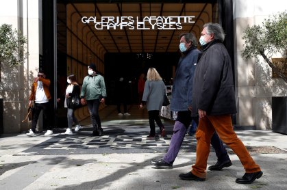 Pedestres caminham em frente à entrada da galeria Lafayette, em Paris, França