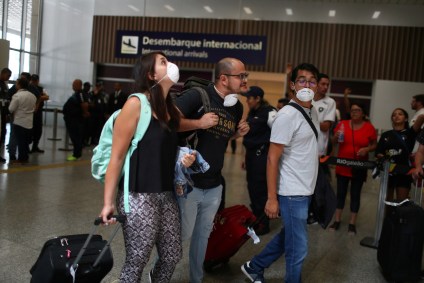 Turistas em aeroporto com máscaras