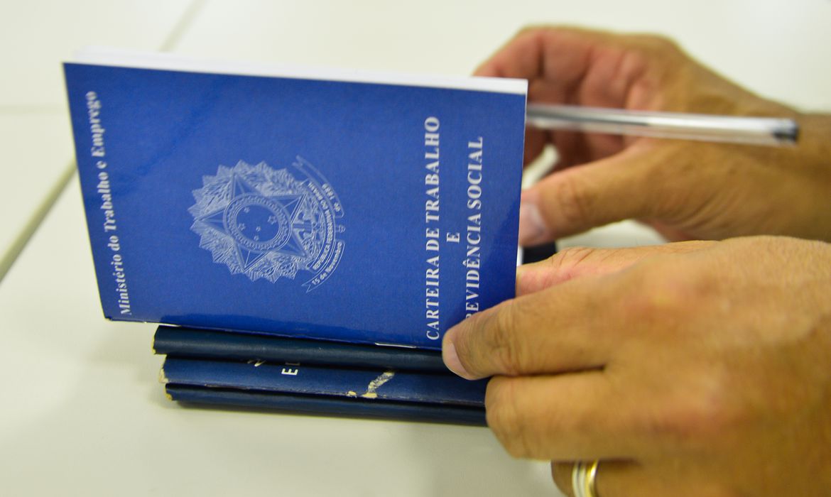 Homem folheia carteira de trabalho  