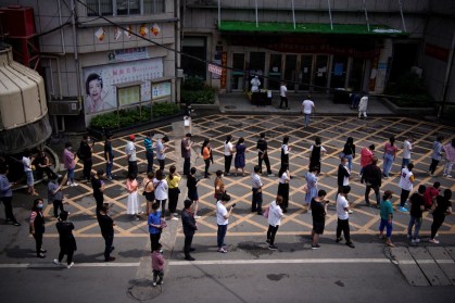 Moradores fazem fila para serem testados em Wuhan, na China