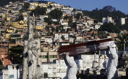 Coveiros com roupas de proteção carregam caixão no Rio de Janeiro